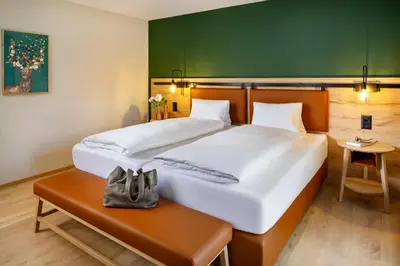 a hotel room with two beds and a table at Hotel Hirschen Wildhaus in Wildhaus