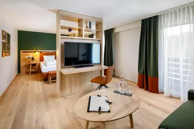 a living room with a television and a table at Hotel Hirschen Wildhaus in Wildhaus