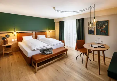 a hotel room with a bed and a table at Hotel Hirschen Wildhaus in Wildhaus