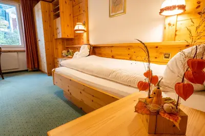a bedroom with a bed and a table in a room at Hotel Sonne in Wildhaus