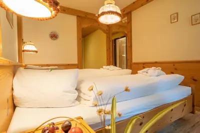 a bedroom with two beds and a mirror at Hotel Sonne in Wildhaus