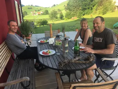 a group of people sitting around a table on a patio at BnB chezlise in Urnäsch