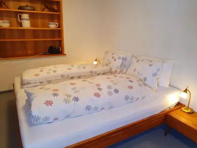 a bed with a white comforter and two pillows at Adler Hotel in Appenzell