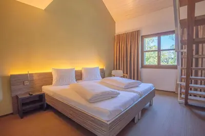 a bedroom with a bed with white sheets and a window at Hotel Restaurant Seegarten in Arbon