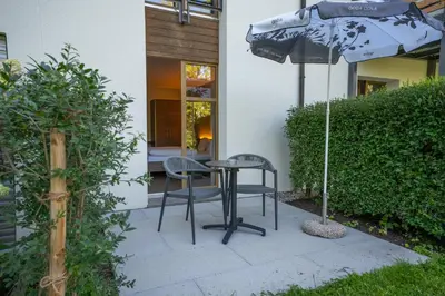 a patio with a table and two chairs and an umbrella at Hotel Restaurant Seegarten in Arbon