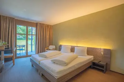 a bedroom with a large bed with white pillows at Hotel Restaurant Seegarten in Arbon