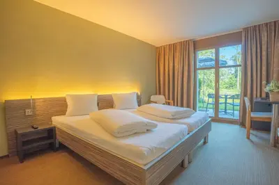 a bedroom with a large bed with white pillows at Hotel Restaurant Seegarten in Arbon