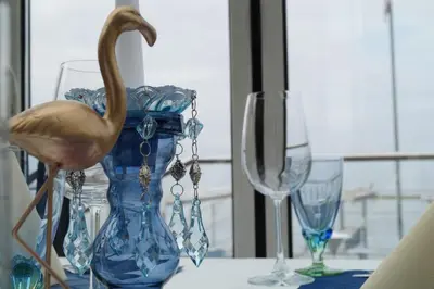 a bird standing on a table with three wine glasses at Bodenseehotel Weisses Rössli in Staad