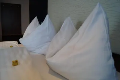 a pile of pillows sitting on top of a bed at Bodenseehotel Weisses Rössli in Staad