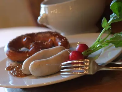 a plate of food with a fork and a donut at Hotel Brauerei Frohsinn in Arbon