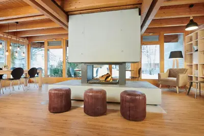 a living room with a fireplace and some chairs at Reka-Feriendorf Wildhaus in Wildhaus