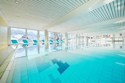 a swimming pool with a view of the mountains at Reka-Feriendorf Wildhaus in Wildhaus