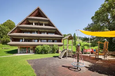 a house with a playground and a swing at Reka-Feriendorf Wildhaus in Wildhaus
