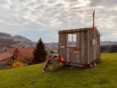 a small wooden house on a hill with a window at Hof Dietrich in Herisau