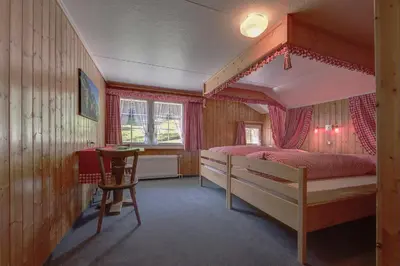a bedroom with a bed and a table in it at Waldgasthaus Lehmen in Weissbad