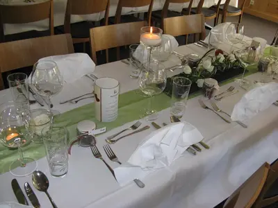 a table with a white table cloth and wine glasses at Waldgasthaus Lehmen in Weissbad
