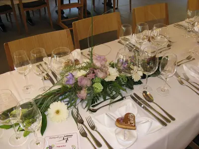 a table with wine glasses and flowers on it at Waldgasthaus Lehmen in Weissbad
