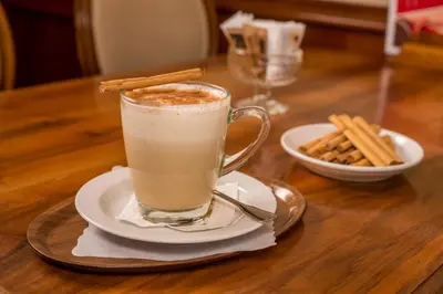 a cup of coffee sitting on a table with a plate at Hotel Appenzell in Appenzell