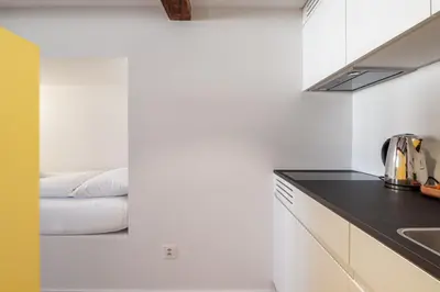 a kitchen with a counter top and a bed in a room at Linde Heiden Swiss Quality Hotel in Heiden