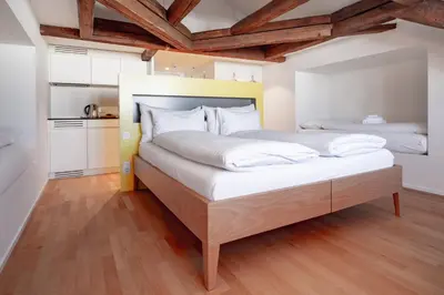a bedroom with a large bed with white sheets at Linde Heiden Swiss Quality Hotel in Heiden