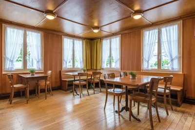 a dining room with tables and chairs and windows at Linde Heiden Swiss Quality Hotel in Heiden