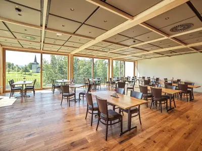 a dining room with tables and chairs and large windows at Hotel Rössli Tufertschwil in Lütisburg