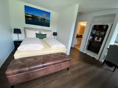 a bedroom with a large bed and a leather couch at Trompeterschlössle Hotel & Residence in Tägerwilen