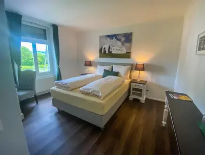 a bedroom with a bed and a table and a window at Trompeterschlössle Hotel & Residence in Tägerwilen