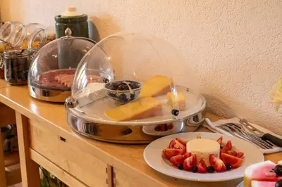 a counter top with a plate of cheese and fruit at Hotel am Schönenbühl in Speicher