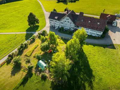 an aerial view of a large house in a field at Hotel am Schönenbühl in Speicher