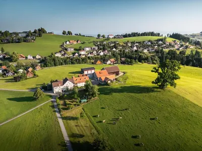 an aerial view of a village on a green field at Hotel am Schönenbühl in Speicher