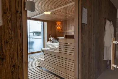 a hotel room with a bed and a table and chairs at Seemöwe Wellnesshotel Swiss Quality in Güttingen