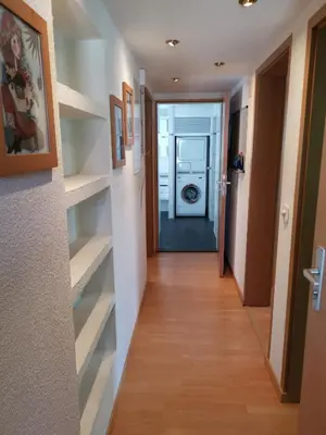 a hallway leading to a laundry room with shelves at Ferienwohnungen im Fürstenland in Gossau