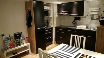 a kitchen with a black refrigerator and a table at Ferienwohnungen im Fürstenland in Gossau