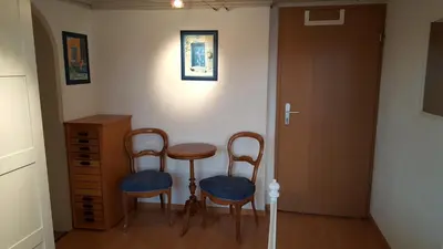 a room with two chairs and a table and a door at Ferienwohnungen im Fürstenland in Gossau