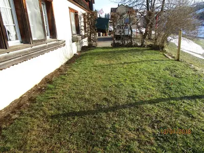 a yard of grass next to a house at Stofel 2078 in Unterwasser