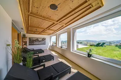 a living room with a couch and a large window at Hotel Landgasthof Eischen in Appenzell