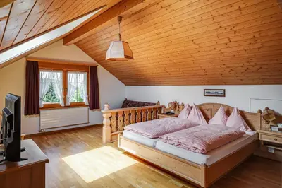 a bedroom with a bed and a wooden ceiling at Hotel Landgasthof Eischen in Appenzell