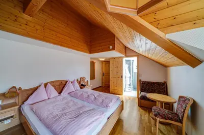 a bedroom with a bed and a wooden ceiling at Hotel Landgasthof Eischen in Appenzell