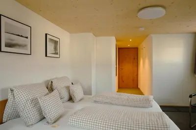 a bedroom with a bed with checkered pillows at Hotel Landgasthaus Neues Bild, Eggerstanden in Appenzell