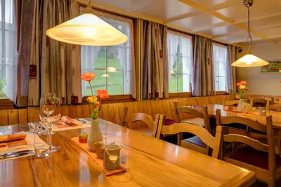 a dining room with wooden tables and chairs at Hotel Landgasthaus Neues Bild, Eggerstanden in Appenzell