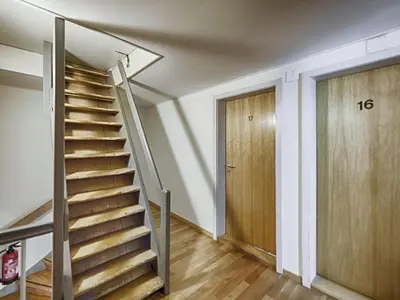 a staircase in a room with a wooden door at Hotel Weisses Kreuz in St. Gallen