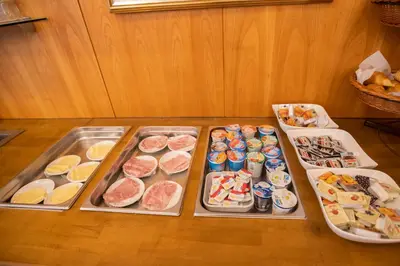 a table with four trays of different types of food at Hotel Rotes Kreuz in Arbon