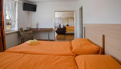 a bedroom with two beds and a living room at Hotel Rotes Kreuz in Arbon