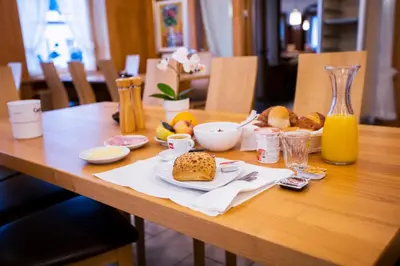 a table with a plate of bread and orange juice at Hotel Rotes Kreuz in Arbon