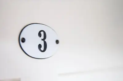 a clock with the number three on a white wall at Hotel Rotes Kreuz in Arbon