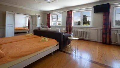 a bedroom with a bed and a living room at Hotel Rotes Kreuz in Arbon