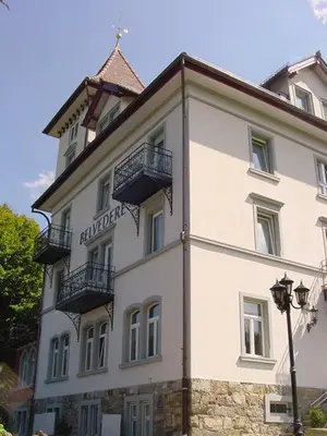 a large white building with balconies on top of it at Hotel Restaurant Belvedere in Weissbad