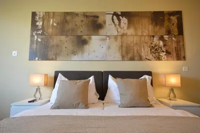 a bedroom with a bed with two lamps and a painting at Hotel Bodensee-Arena in Kreuzlingen