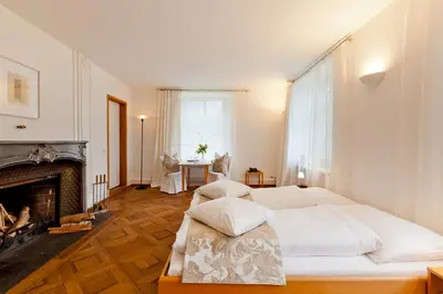 a bedroom with two beds and a fireplace at Schloss Wartegg in Rorschacherberg